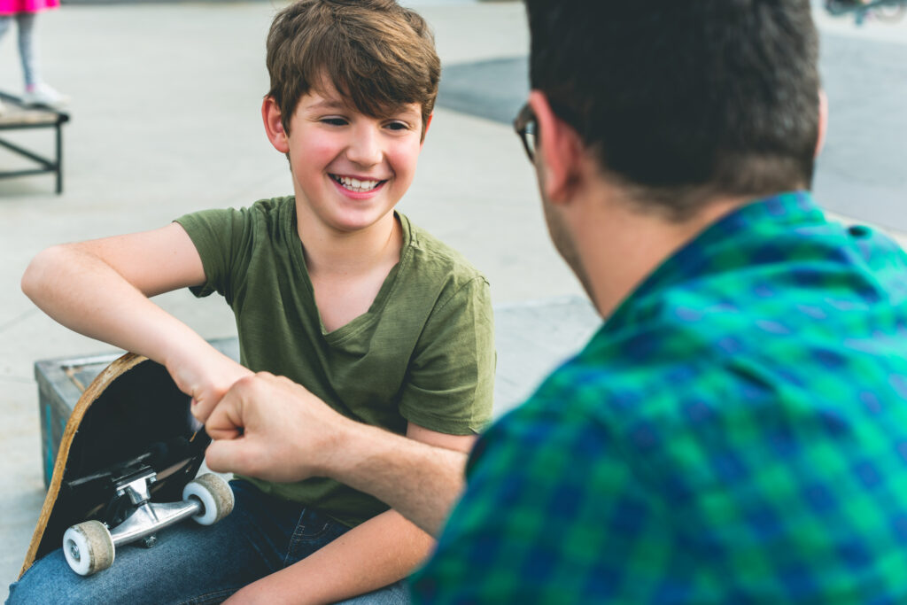 A teenage boy laughing with a mentor