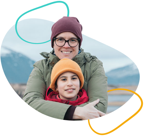 A woman and young person wearing hats in a mountain landscape.